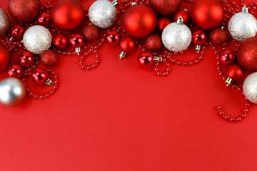 Christmas composition. Christmas red and gold decorations on a red background. Top view, space for text.