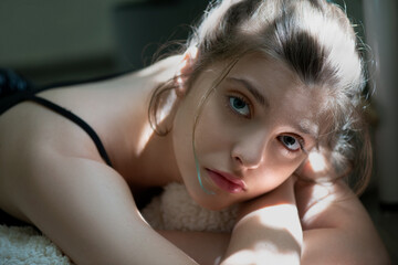 Young beautiful woman with natural clean perfect skin in the room. Portrait of beauty girl in natural light, selective focus