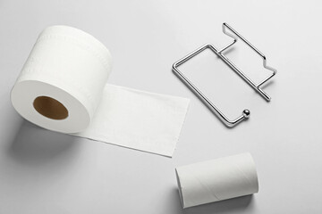 Holder, cardboard tube and toilet paper roll on white background