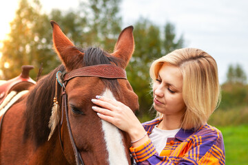 Fototapeta premium Beautiful young blond woman with a horse, portrait.
