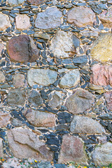 Old stone wall made of large and small stones as a natural background
