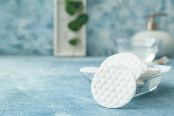 Glass bowl with new cotton pads on table, closeup