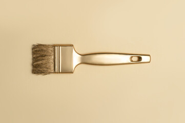 Gold color paintbrush on beige background. Horizontal creative theme poster, greeting cards,...