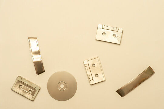 Gold fancy retro old audio cassettes, film strip, disc on beige color background. Horizontal media theme poster, greeting cards, headers, website and app - Powered by Adobe