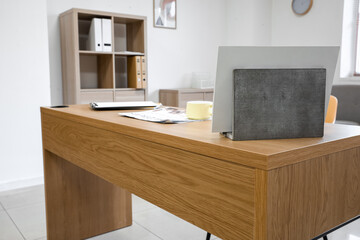 Stylish office workplace with big wooden table