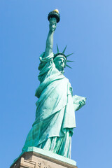 Fototapeta premium Low angle view of statue of liberty with blue sky during sunny day in summer. Liberty Island, New York. United States.