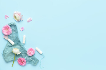 Menstrual tampons, panties and flowers on blue background