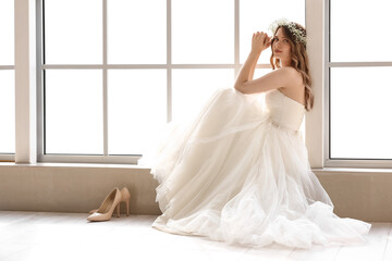 Beautiful young bride sitting on window sill - Powered by Adobe
