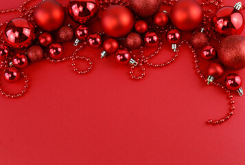 Christmas composition. Christmas red decorations on a red background. Top view, space for text.