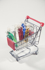 Colorful candies in the small metal shopping cart on the white background