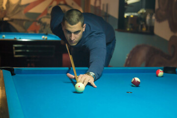 Man plays a billiard at the club