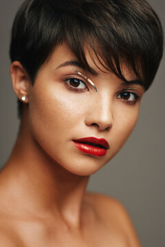 Portrait of beautiful young woman with short hair and red lipstick on her lips isolated on studio background