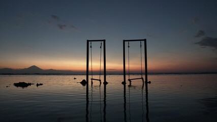 Swing late afternoon sunset summer travel visit island frame ocean sea colors sunset Bali Indonesia Gili waves horizon darken mountain clouds