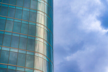 Curved building exterior with glass curtain wall against the cloudy sky at Salt Lake City in Utah