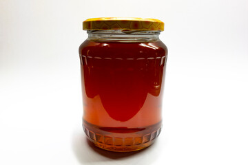 Fresh honey from bee plastic in a glass bottle with a cap on a l