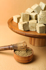 Stand with tasty hojicha marshmallows, powder and chasen on color background