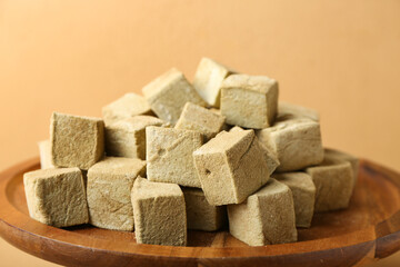 Stand with tasty hojicha marshmallows on color background, closeup
