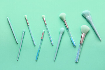 Different makeup brushes on color background