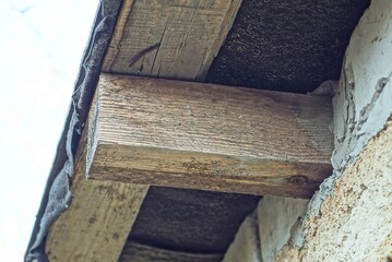 part of the roof from the formwork of one brown wooden beam on the wall outside