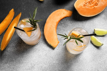 Glasses of cold cocktail, melon and lime on black and white background