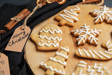 Board with Christmas gingerbread cookies on dark background