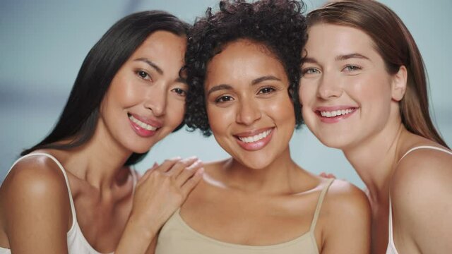 Beauty Portrait of Three Diverse Multiethnic Models on Isolated Background. Laughing Happy Asian, Black and Caucasian Women with Natural, Healthy Skin. Wellness, Spa, Cosmetology, Skincare Concept.