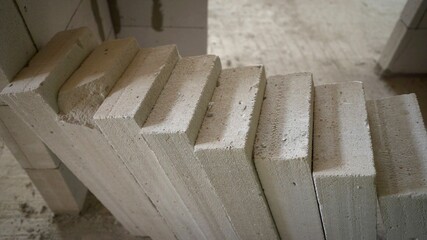 Construction of a multi-storey building from blocks. Concrete blocks are lined up at the construction site.