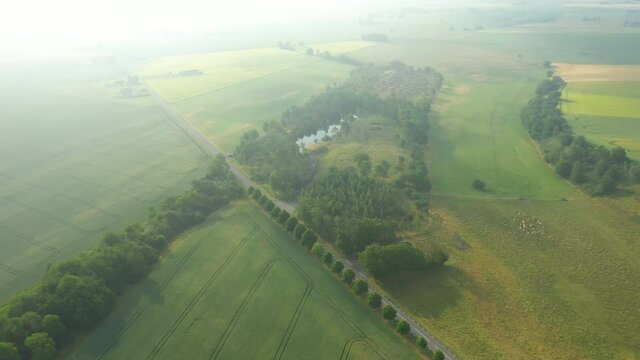 Aerial flying over rural landscape covered in morning mist