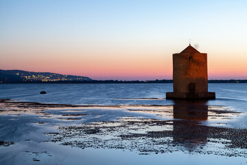 The iconic windmill in the lagoon, Orbetello, Monte Argentario, Tuscany, during a colorful sunset...
