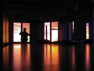 Rear view silhouette of a businessman looking out of a window in a boardroom