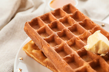 Plate with tasty Belgian waffles and butter on table, closeup