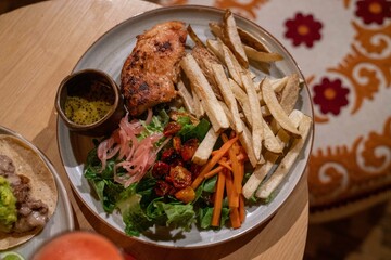 delicious chicken, fries, and salad entree at a latin american restaurant during the day