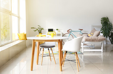 Interior of light dining room with bicycle and couch