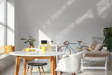 Interior of light dining room with bicycle and couch