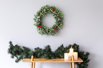 Beautiful mistletoe wreath with Christmas decor on table in room - obrazy, fototapety, plakaty