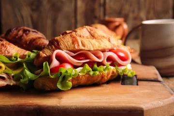 Zelfklevend Fotobehang Bord met heerlijke croissantsandwiches op houten ondergrond © Pixel-Shot