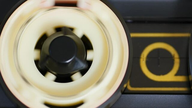 Tape reel starts to record. Zoom out. Cassette tape assembly of audio recorder spinning slowly. Close up, 4K, static shot. Tape in use playing in video cassette player
