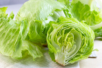 Fresh green iceberg lettuce salad leaves cut on light background on the table in the kitchen. - 468043111