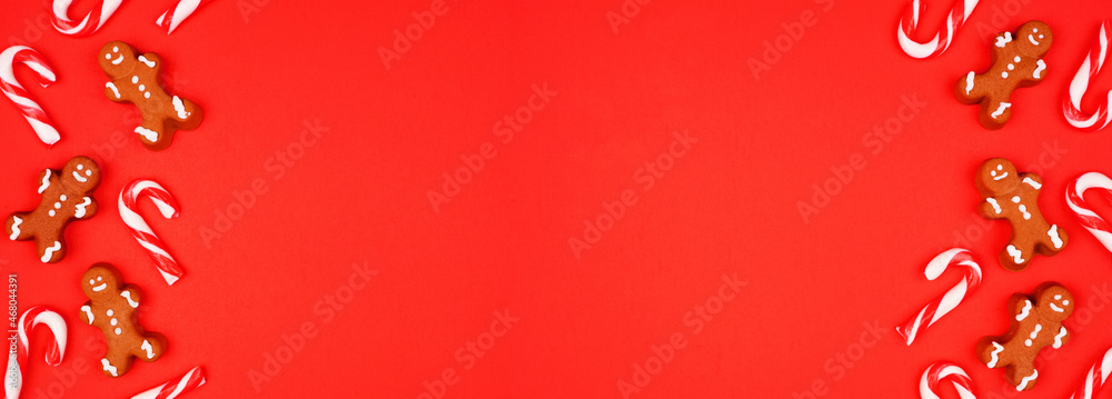 Poster Christmas double border of gingerbread cookies and peppermint candy canes. Above view on a red paper background with copy space.