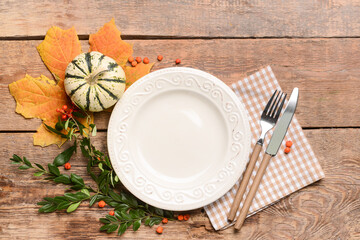 Composition with table setting and pumpkin on wooden background