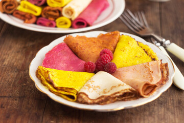 Multi-colored flat pancakes made from natural dyes. Hearty snack, yellow, pink and red pancakes