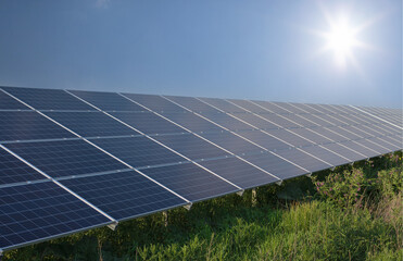 Photovoltaic solar panels as a renewable energy source. Solar panel, clear blue sky and sun.