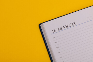 Notepad or diary with the exact date on a yellow background. Calendar for March 16 - spring time. Space for text.