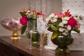 Bride and groom cup on the table with flowers in background wedding day