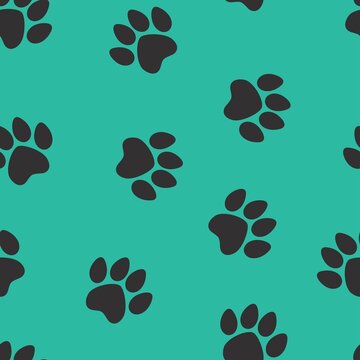 black footprints of a cat on a green background. seamless abstraction of animal footprints for clothing or print