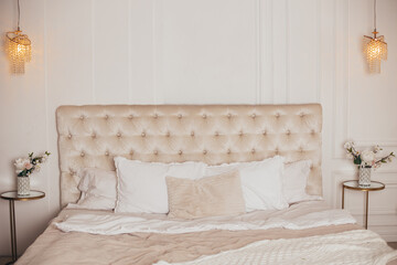 Beautiful bedroom in beige colours with flower bouquet