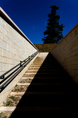 An exterior stone staircase symmetrically shaded by the sun lit.