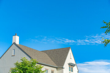 Home exterior with asphalt composite shingle roof and chimney
