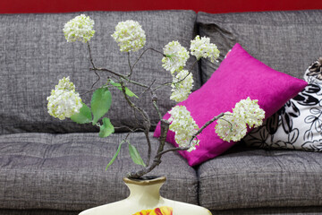 Cozy living room with couch and cushions, adorned with withe flowers