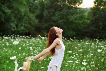 Obraz premium Woman in white dress hat holding flowers nature walk